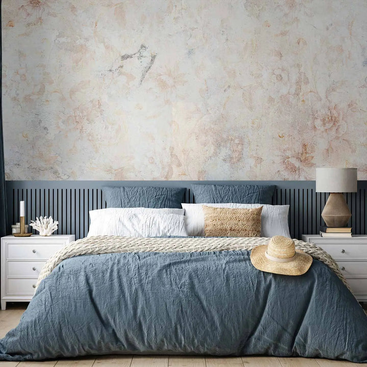 Photo wallpaper with a vintage floral motif and antique texture in a bedroom interior behind a double bed with blue bedding and a light wooden plank floor