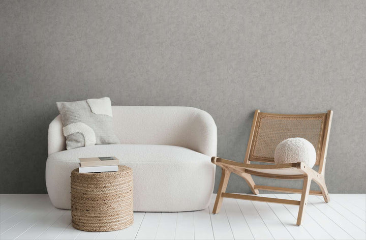 Gray wallpaper in a modern living room interior with a white sofa, wooden lounge chair, and white wood plank flooring