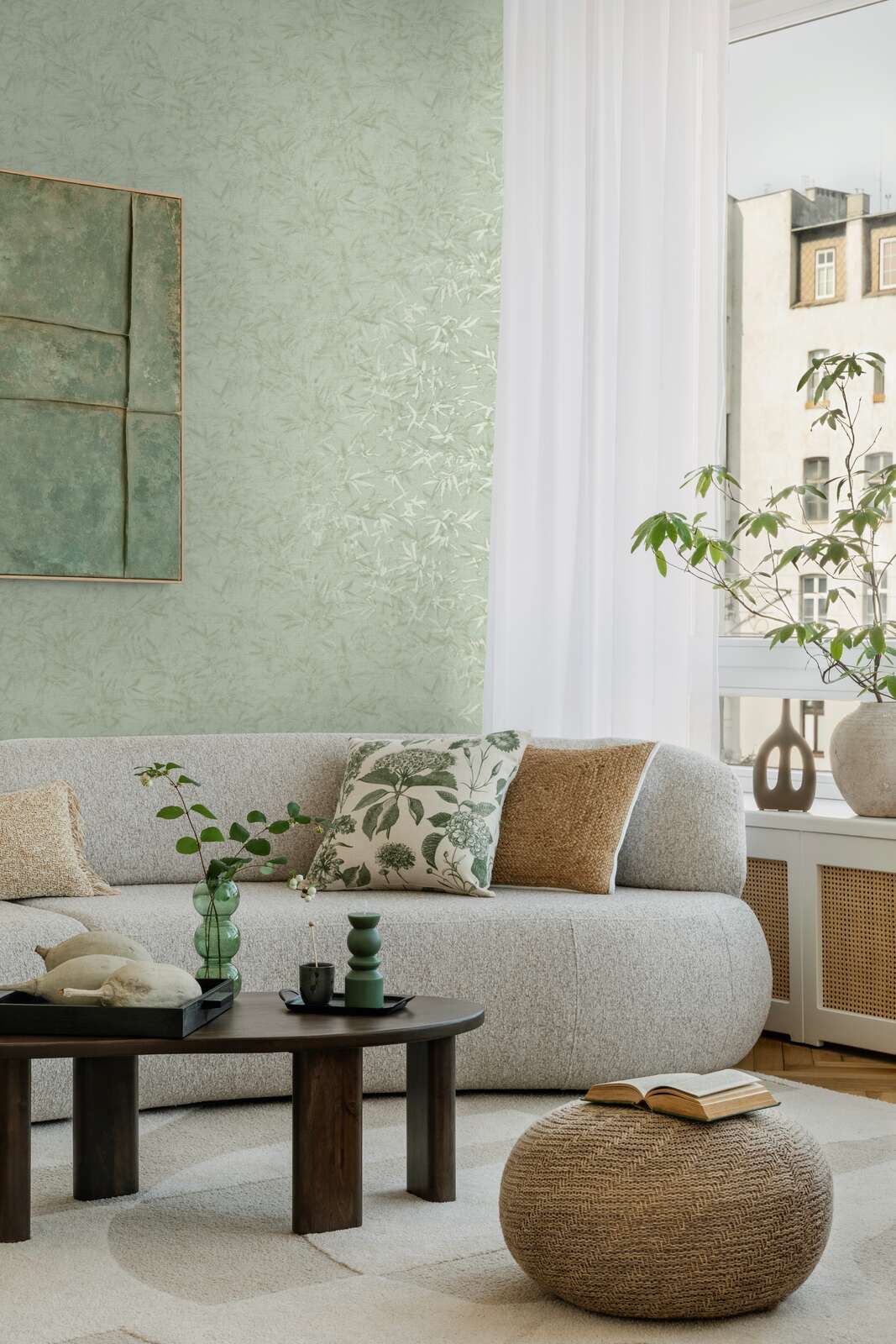 Light green bamboo leaf pattern wallpaper in a bright living room interior with a sofa, coffee table, and natural wood parquet flooring with a rug