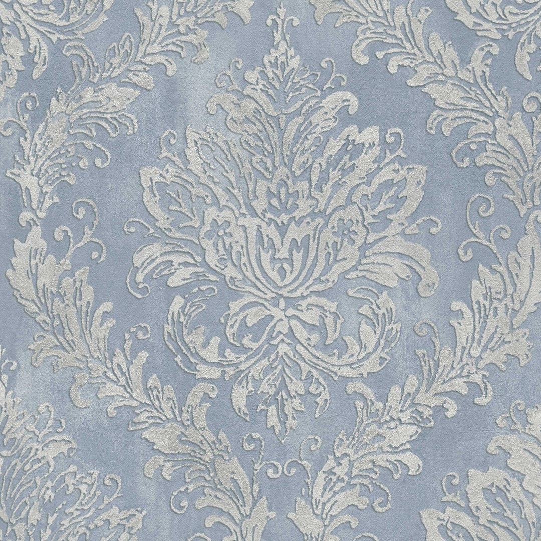 Bluish-gray wallpaper with a silvery damask ornament, close-up