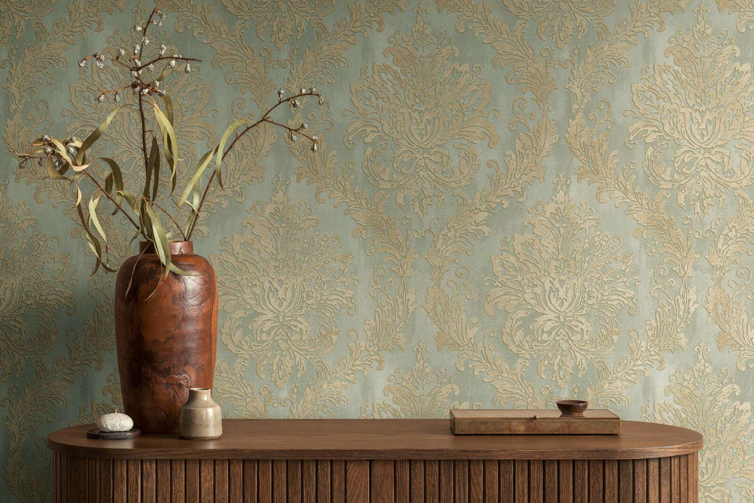 Light greenish damask pattern wallpaper in an interior behind a wooden cabinet with a decorative wooden vase