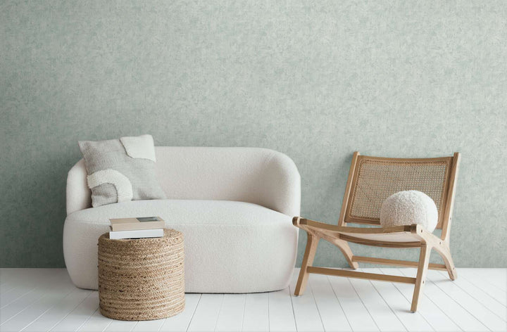 Light bluish-gray wallpaper in a modern living room interior with a white sofa and wooden lounge chair
