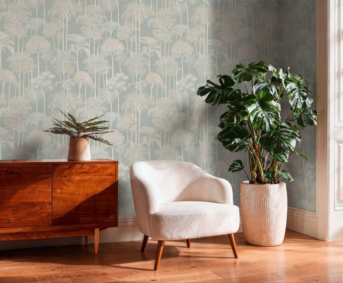 Zaļas tropiskā stila neaustas tapetes ar palmu kokiem košā viesistabas interjerā. SKU: 3012106, AS Creation.