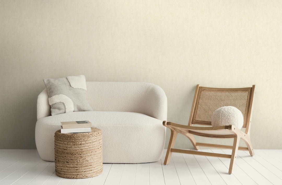 Kreminės spalvos tapetai moderniame svetainės interjere su balta sofa, mediniu foteliu ir baltų medinių lentų grindimis