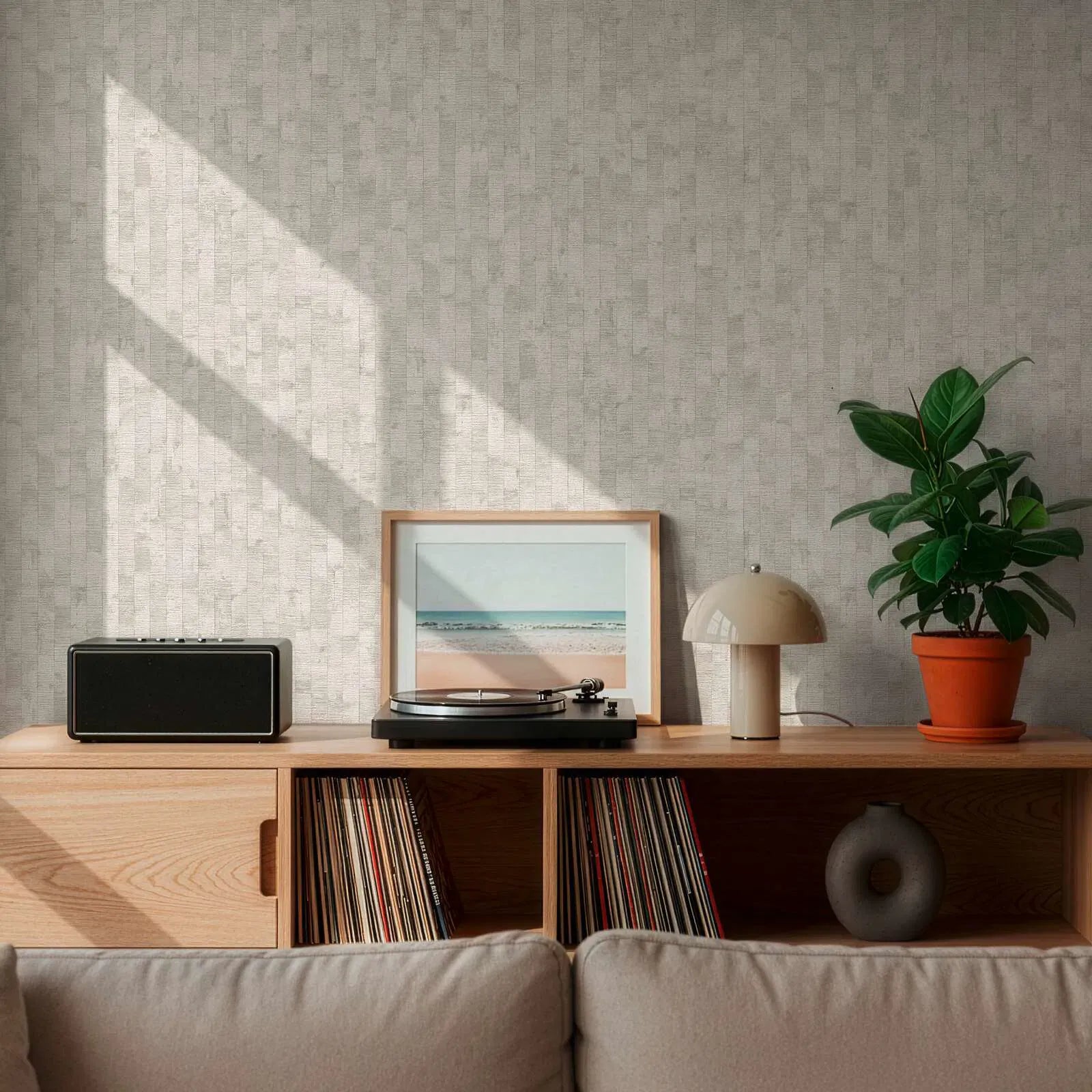 Gaiši pelēkas tapetes ar dabisku sienu paneļu izskatu stilīgā viesistabas interjerā. SKU: 3007103, AS Creation.