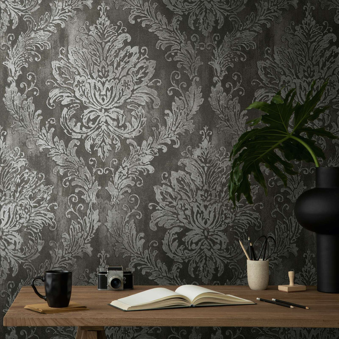 Dark gray damask pattern wallpaper above a wooden desk