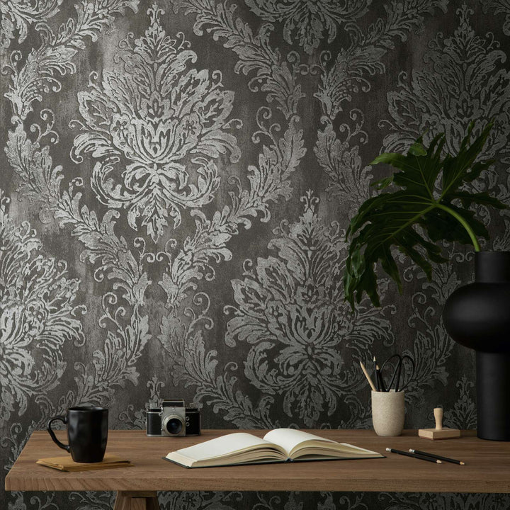 Dark gray damask pattern wallpaper above a wooden desk