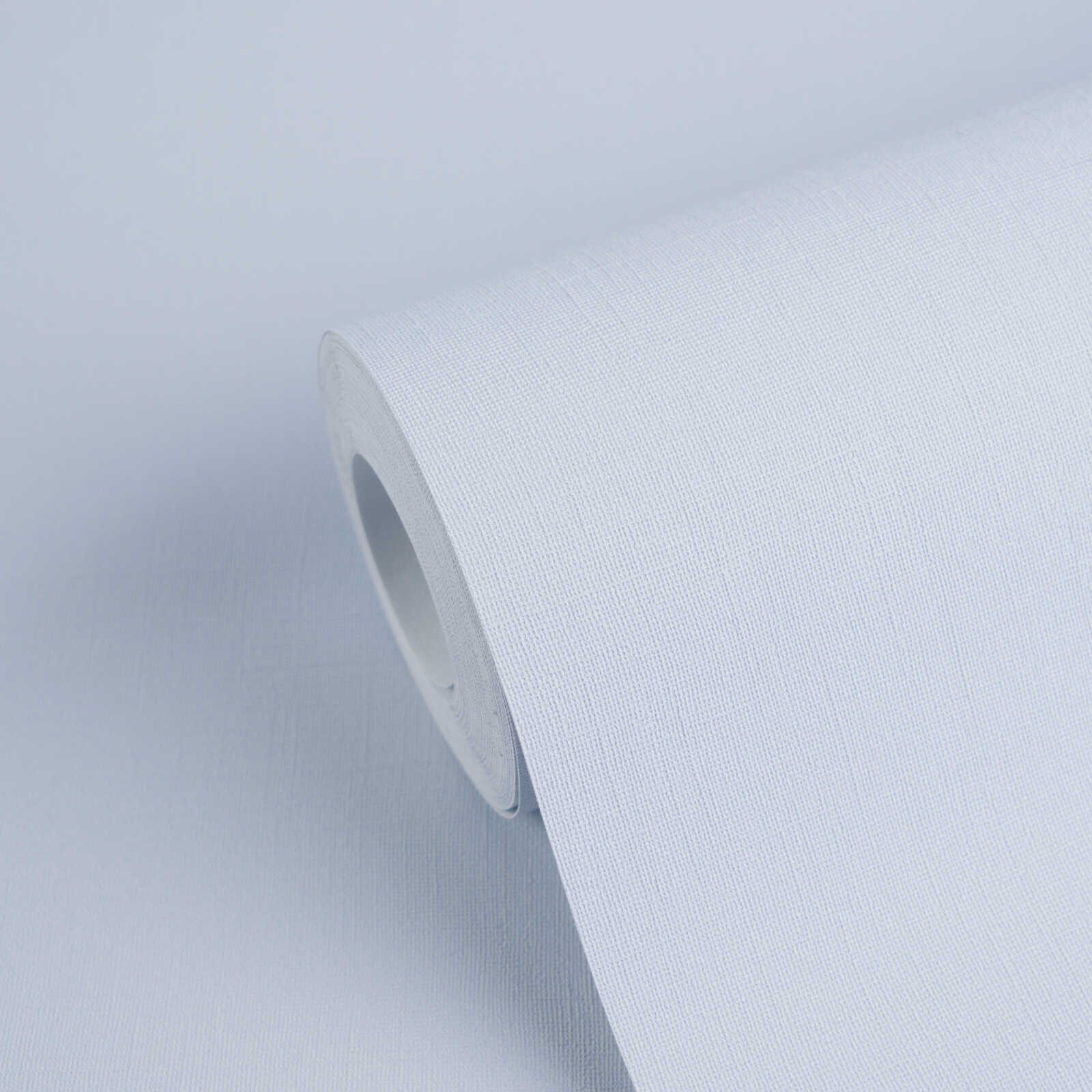Light blue textured wallpaper roll with a close-up view of the fabric-like pattern