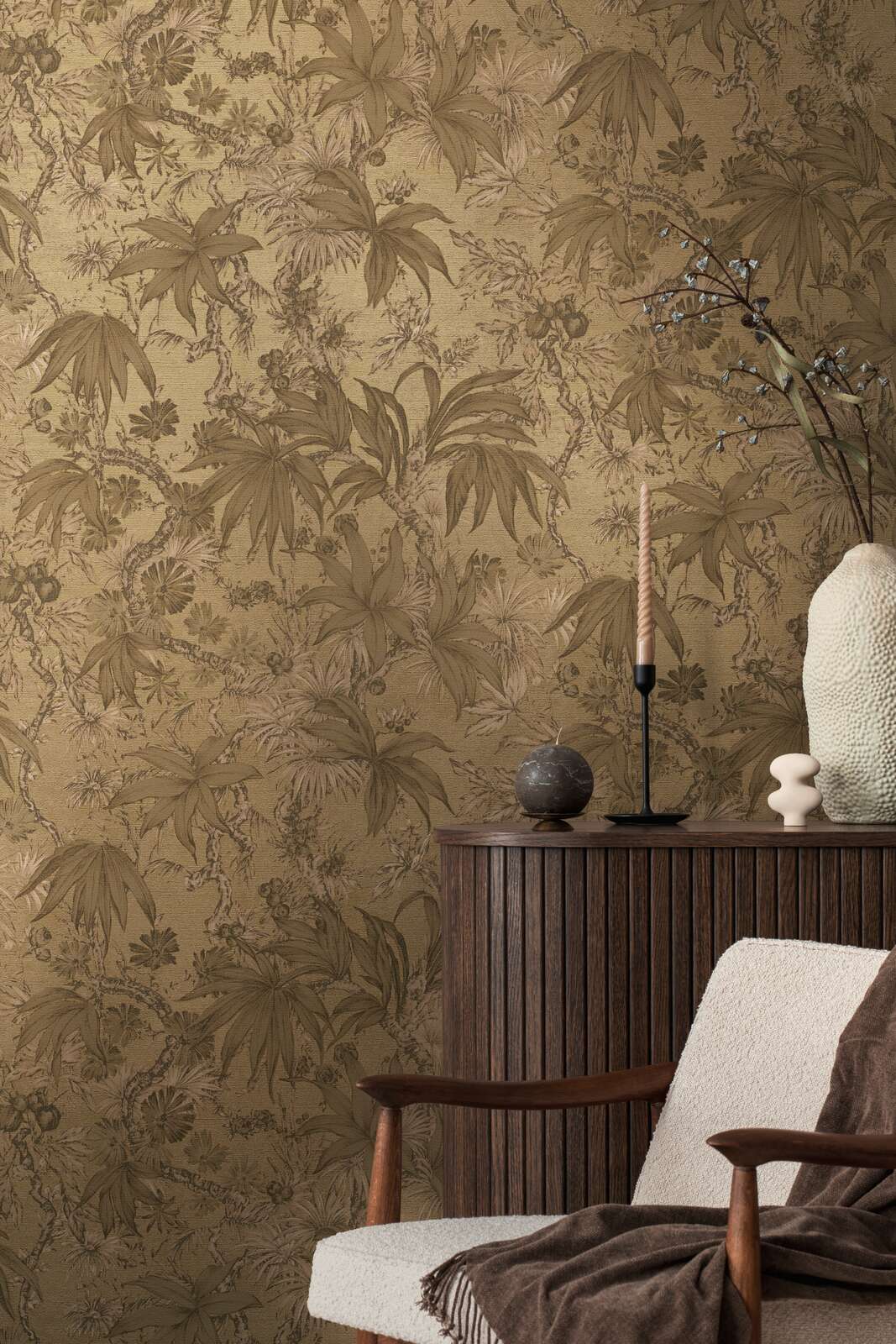 Golden-brown botanical pattern wallpaper in an interior behind a wooden cabinet and lounge chair with decorative accents